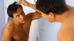Man Checking Hair in Mirror