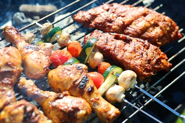 Assorted meat and vegetables on barbecue grill cooked for summer family dinner